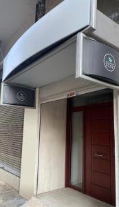 una puerta delantera de un edificio con una señal encima en E2G URBAN STAY #G en Tesalónica