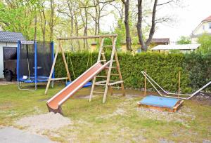 a playground with two swings and a slide at Ferienhaeuser im Ostseebad Baabe in Baabe