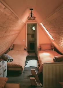 two beds in a room with a attic at Acasă Straja - Casa Vintage in Lupeni +29 photos
