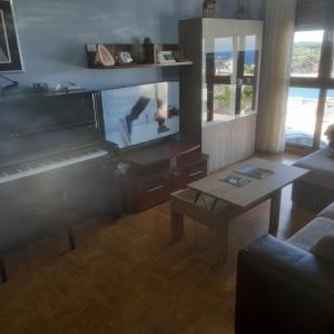 Sala de estar con piano y mesa de centro en LUARCAPLAYA APARTAMENTO Plazas de garaje incluidas, en Luarca