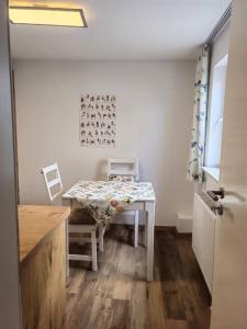 une cuisine avec une table, une table blanche et une chaise dans l'établissement Sehr schöne seperate Wohnung 2-Zimmer Küche/Bad, à Erzhausen