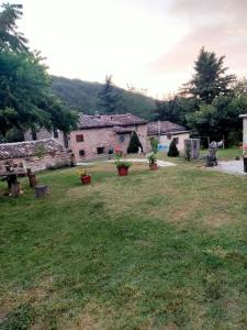 un patio con macetas y un edificio de piedra en Il giardino dei sogni, en Montefortino