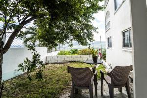 un patio con 2 sillas y una mesa en un patio en Skyline Suites, breathtaking mountains & city view apts, en Montego Bay