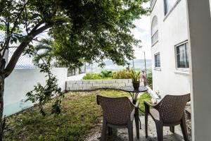 a patio with two chairs and a table in a yard at Skyline Suites, breathtaking mountains & city view apts in Montego Bay