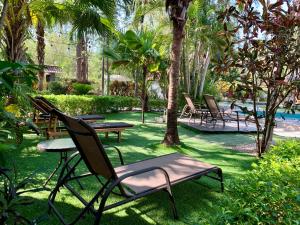 un patio con sillas, una mesa y una piscina en Hotel El Manglar, en Playa Grande