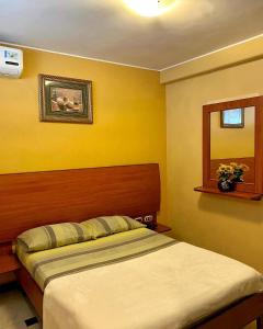 a bedroom with a bed and a mirror at Hostal Montesa in Guayaquil