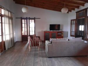 sala de estar con sofá, sillas y TV en Basilia - Casas de campo en Ruiz