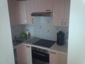 a kitchen with white cabinets and a stove top oven at Appartementhaus Hochkönig 1 - Alpenrose in Mühlbach am Hochkönig