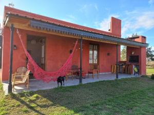 una casa roja con una hamaca delante en Basilia - Casas de campo en Ruiz