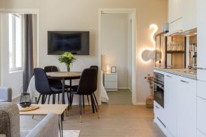 a living room with a table and chairs and a kitchen at Apartment Marinan Portti B37 kaksio Kalajoki in Kalajoki