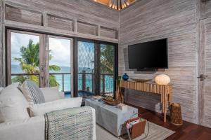 a living room with a flat screen tv and a couch at The Hideout in Jost Van Dyke