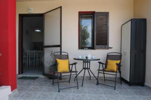 a table with two chairs and a table with yellow pillows at Aris House - Cretan Hospitality in Agios Nikolaos