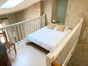 sypialnia z białym łóżkiem z poduszkami w obiekcie Maison de campagne w mieście Rions