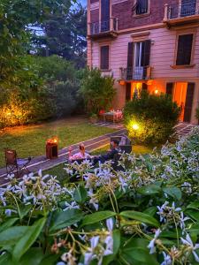 two people sitting in a garden in front of a house at Vagabunda Sea & Garden in Pesaro