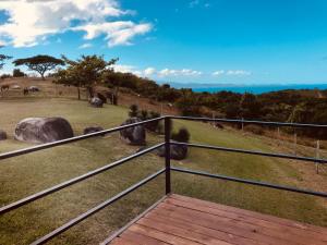 a balcony with a view of a field with rocks at Lejos Eco Retreat in Vieques