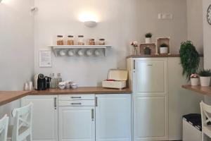 uma cozinha com armários brancos e uma bancada em Vicolo Fiore Affittacamere em Matera