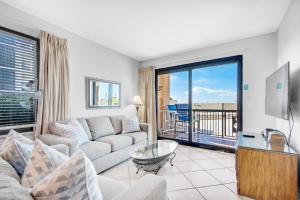 a living room with a couch and a large window at SunDestin 101 in Destin