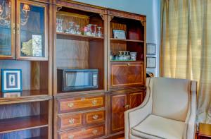 een woonkamer met een tv en een stoel bij Steele Cottage in Vicksburg