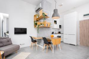 a kitchen and living room with a table and chairs at Kraków Loft in Krakow