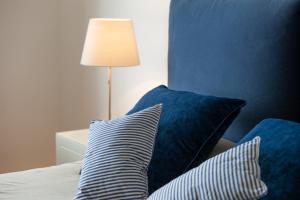 a bed with two blue pillows and a lamp at Gaeta Terrace in Gaeta