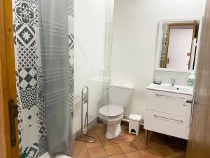 a bathroom with a toilet and a sink and a shower at Maison de campagne in Rions