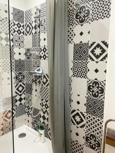 a bathroom with black and white tiles at Maison de campagne in Rions