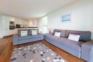 a living room with two couches and a kitchen at Coast in St Ives