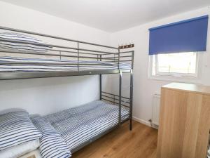 a bedroom with two bunk beds and a window at Llety'r Bugail in Caernarfon