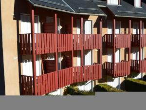 a building with red balconies on the side of it at Studio cabine 2 pers avec parking à Esquièze-Sère - FR-1-402-124 in Esquièze - Sère +2 photos