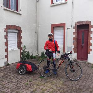 un hombre está de pie junto a una bicicleta en Chambres Zola en Nantes