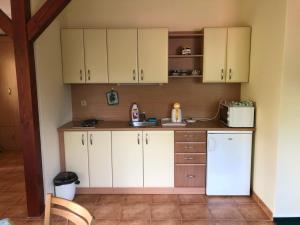 a kitchen with white cabinets and a white refrigerator at APARTMÁNY SMRAĎAVKA č.ev.52 in Buchlovice