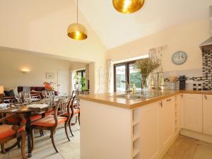 a kitchen and dining room with a table and a counter at Lydgate House Cottage in Yelverton