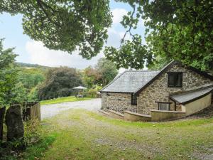 a stone house on a gravel road at Lydgate House Cottage in Yelverton