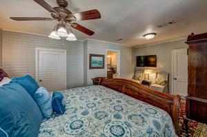 a bedroom with a bed with a ceiling fan at Steele Cottage in Vicksburg