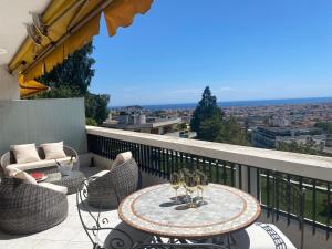 a patio with a table and chairs on a balcony at Dernier Etage d'exception in Nice