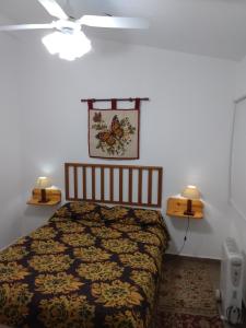 a bedroom with a bed and two lights on the wall at El Tatu in Villa la Bolsa
