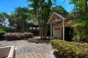 a house with a garden and a patio at Wonderful 1-bed condo, 2min walk to beach & more in Bridgetown