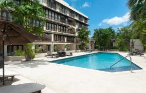 a swimming pool in front of a building at Wonderful 1-bed condo, 2min walk to beach & more in Bridgetown