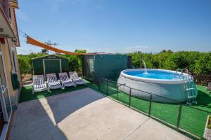 a backyard with a hot tub and chairs at Casita entre naranjas in Formentera de Segura