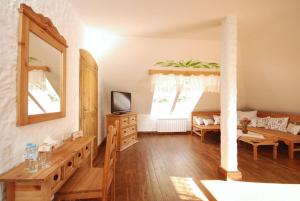 sala de estar con suelo de madera y espejo en Lipowy Gościniec, en Otwock Mały
