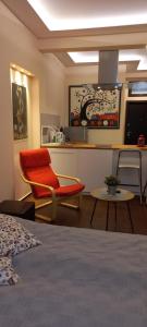 a room with a bed and a chair and a kitchen at Embassy Apartment in Sofia