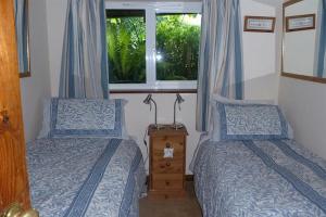 una camera con due letti e una finestra di Willows a Charmouth