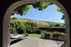 an archway with a bench in a garden at Willows in Charmouth