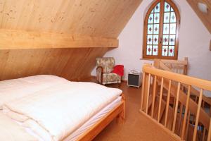 a bedroom with a bed and a chair and a window at Ober der Eller in Brotterode