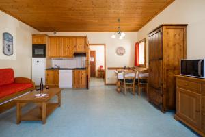 ein Wohnzimmer mit einem roten Sofa und einem Tisch in der Unterkunft Alpes Roc in Pralognan-la-Vanoise