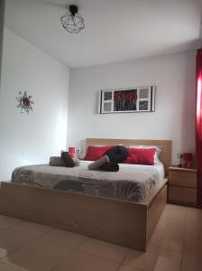 una camera da letto con un grande letto con cuscini rossi di Costa del silencio Atlántico I ad Arona