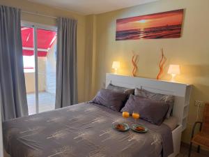 Un dormitorio con una cama con dos platos de comida encima. en Jardín, en Puerto de Santiago 34 fotos más