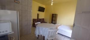 um quarto com uma mesa, uma cama e um frigorífico em Pousada Moradas da Praia em Garopaba