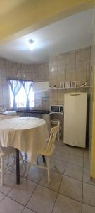 a kitchen with a table and chairs in a room at Pousada Moradas da Praia in Garopaba