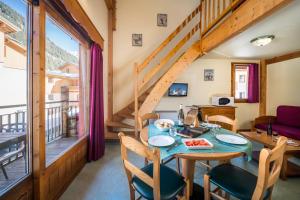jadalnia ze stołem i krzesłami oraz balkonem w obiekcie Alpes Roc w mieście Pralognan-la-Vanoise